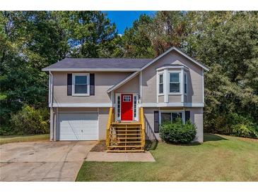 Two-story house with a red door, attached garage, and landscaped yard at 2478 Shady Shoals Ct, Decatur, GA 30034