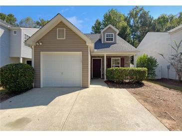 Tan house with white garage door and landscaping at 158 Ilex Dr, Canton, GA 30114