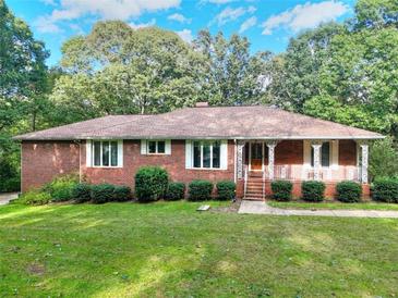 Brick ranch home with landscaped yard and large windows at 452 Hightower Ridge Rd, Covington, GA 30014