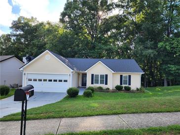 Charming yellow house with a two-car garage at 835 Amelia Grove Ln, Lawrenceville, GA 30045