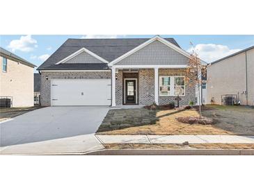 Charming two-story home with gray siding, brick facade, and a covered front porch at 7762 Plymouth Dr, Fairburn, GA 30213