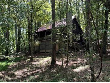 Secluded log cabin nestled in a lush forest setting at 7790 Atlanta Newnan Rd, Chattahoochee Hills, GA 30268