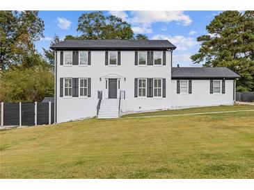 Two-story white house with black accents and a grassy yard at 3636 Evans Rd, Atlanta, GA 30340