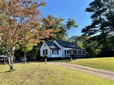 Charming white house with a screened porch and landscaped yard at 3970 Norman Rd, Stone Mountain, GA 30083