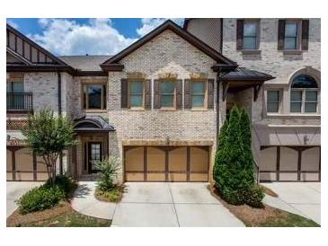 Brick townhouse with two-car garage and landscaping at 1175 Grassy Oat Ln, Lawrenceville, GA 30045
