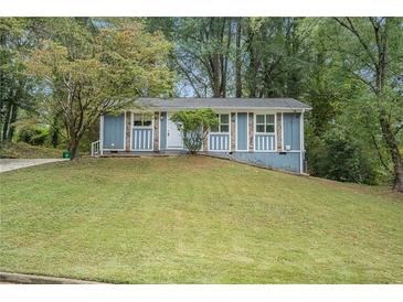 Ranch style home with a blue exterior and well-manicured lawn at 4649 Big Valley Ct, Stone Mountain, GA 30083