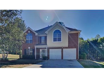 Two story brick home with a three-car garage at 12497 Lakeside Pkwy, Fayetteville, GA 30215