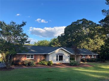 Brick ranch house with a large yard and mature trees at 1078 Highway 92 S, Fayetteville, GA 30215