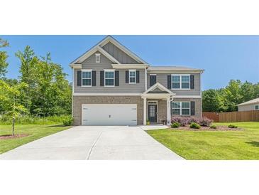 Two-story house with gray siding, brick accents, and landscaping at 6912 Oak Valley Dr, Douglasville, GA 30134