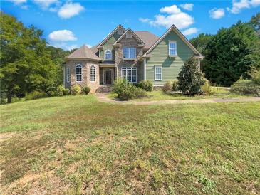 Green two-story house with stone accents and a large yard at 155 Chaparral Trce, Tyrone, GA 30290