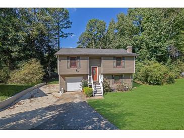 Two story house with attached garage and a green lawn at 4693 Hairston Crossing Rd, Stone Mountain, GA 30083