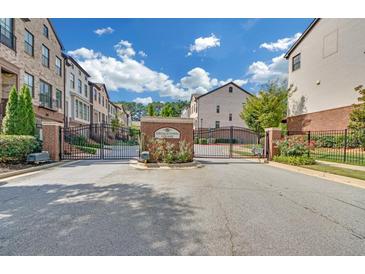 Gated community entrance with brick pillars and iron gates at 4130 Wisconsin Dr, Dunwoody, GA 30338