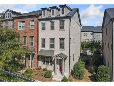 Three-story townhome with brick and light gray siding, and a front porch at 10120 Windalier Way, Roswell, GA 30076