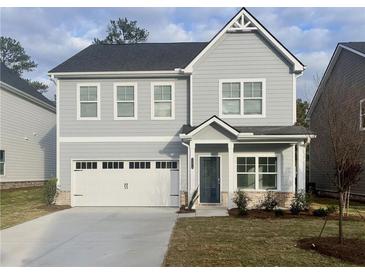 Two-story gray house with two-car garage and landscaping at 11814 Rizvan Pl, Covington, GA 30014