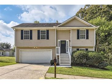 Two-story house with a white garage door and stairs leading to the entrance at 9170 Jefferson Sw Ave, Covington, GA 30014