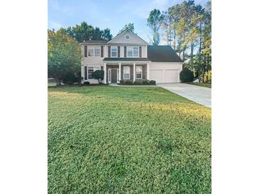 Two-story house with a large front yard, attached garage, and stone accents at 4060 Willowmere Pointe Nw, Kennesaw, GA 30144