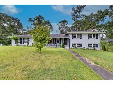 Ranch house with white brick exterior and landscaping at 903 Bingham Ln, Stone Mountain, GA 30083