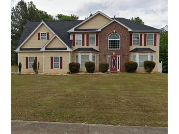 Two-story house with brick and siding, red accents, and a manicured lawn at 300 Redford Trl, Stockbridge, GA 30281