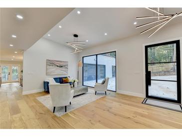 Modern living room with hardwood floors, large windows, and stylish furniture at 5255 Buice Rd, Alpharetta, GA 30022