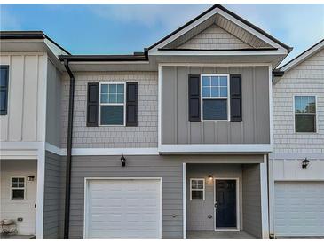 Two-story townhouse with gray siding, black shutters, and a white garage door, offering curb appeal at 5120 Lower Elm St, Atlanta, GA 30349