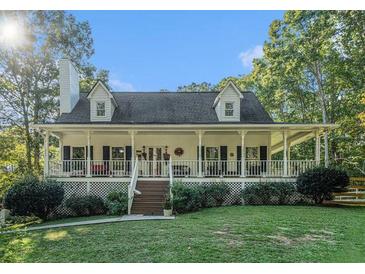 Two-story house with wrap-around porch and mature trees at 511 Rc Thompson Rd, Dallas, GA 30157