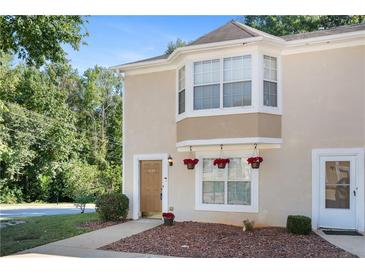 Tan two-story townhouse with a brown door and landscaping at 3127 Fields Dr, Stonecrest, GA 30038