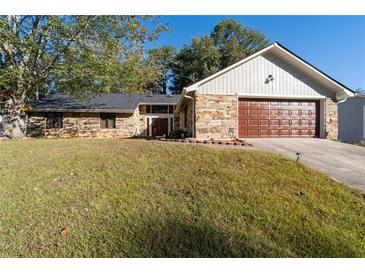 Stone and wood exterior, two-car garage, and nicely landscaped yard at 5934 S Deshon Ct, Lithonia, GA 30058