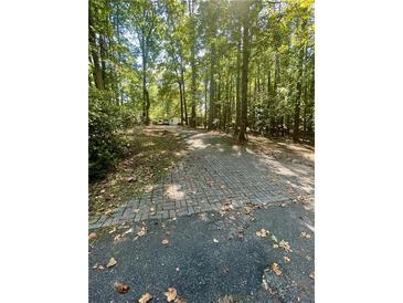 Brick driveway leading to a home nestled in a wooded area at 3246 Glen Wallace Dr, Cumming, GA 30040