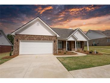 Brick ranch home with white trim, two-car garage, and landscaped yard at 911 Park Place St, Social Circle, GA 30025