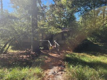Rustic house nestled in a wooded area with a small deck at 2281 Carr Ne Rd, Conyers, GA 30012