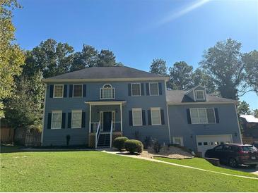 Two story blue house with attached garage at 1958 Stonewood Dr, Lithia Springs, GA 30122
