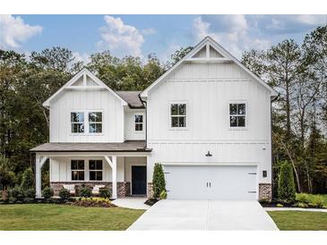 Two-story farmhouse style home with white siding, brick accents and 2-car garage at 118 Henley St, Canton, GA 30114