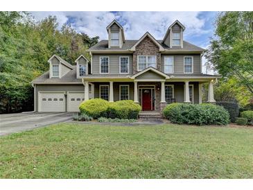 Two-story house with stone accents, a red door, and a landscaped lawn at 1720 Mountainside Dr, Cumming, GA 30040