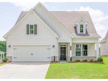 Charming farmhouse-style home with a two-car garage and manicured lawn at 7375 Winderlea Ln, Cumming, GA 30040