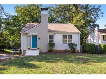 Charming single story home with teal door and manicured lawn at 1880 Vesta Ave, Atlanta, GA 30337