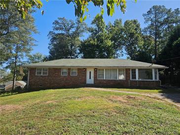 Brick ranch house with a green roof and grassy yard at 3801 Orchard Se Rd, Smyrna, GA 30080