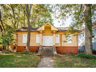 Charming yellow house with a front porch and steps at 418 N Highland Ne Ave, Atlanta, GA 30307