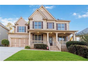Brick house with a large front yard and a three-car garage at 1712 Country Wood Dr, Hoschton, GA 30548