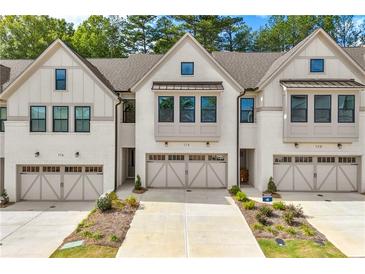 Three-unit townhome building with neutral siding and garages at 118 Briargate Dr, Johns Creek, GA 30097