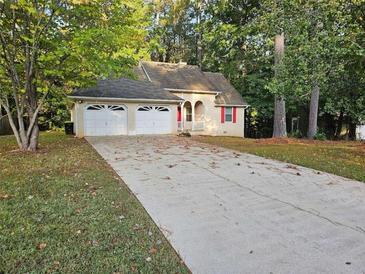 House exterior with a two-car garage and mature trees at 237 Hillandale Dr, Stockbridge, GA 30281