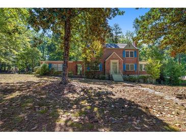 Brick house with blue shutters, landscaped yard, and spacious front porch at 2490 Cascade Sw Rd, Atlanta, GA 30311