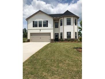 Two-story house with white siding, gray garage door, and manicured lawn at 3035 Chris Cir, Villa Rica, GA 30180