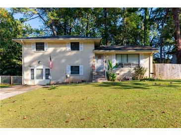Brick ranch home with a well-manicured lawn and American flag at 3208 Edgemont Way, Decatur, GA 30032