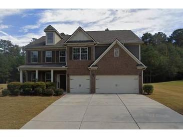 Two-story brick home with a three-car garage and landscaped front yard at 1437 Bourdon Bell Dr, Conyers, GA 30013