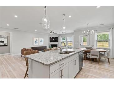 Open kitchen with island, stainless steel appliances, and breakfast area at 402 Beacon Way, Villa Rica, GA 30180