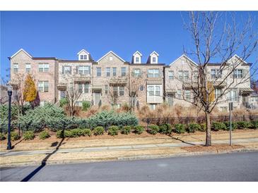 Brick townhouses with a manicured lawn and black fence at 1813 Hislop Ln, Atlanta, GA 30345