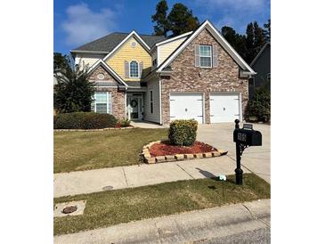 Beautiful two-story home with a brick and siding exterior, two-car garage, and landscaped lawn at 165 Summit Point Dr, Fayetteville, GA 30214