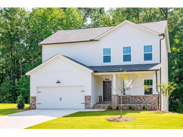Two-story house with white siding, stone accents, and a two-car garage at 134 Henley St, Canton, GA 30114