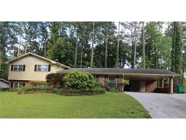Ranch style home with brick facade, carport, and well-maintained lawn at 2501 Henderson Mill Ne Rd, Atlanta, GA 30345