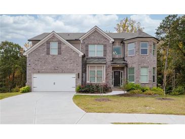 Two-story house with brick facade and a large driveway at 4203 Shandi Cv, Hoschton, GA 30548